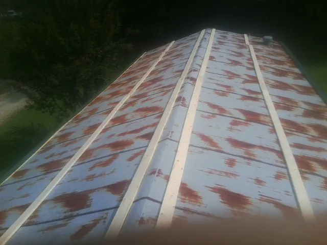 Rusted metal roof panels with new wood purlins before replacement — Storm Damage Roof Repair in Camilla by Roofing Brothers
