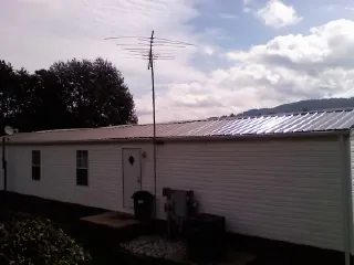 New metal roof on a single wide mobile home with a TV antenna in Camilla